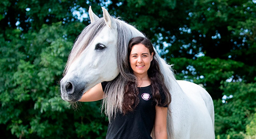 Brown-haired woman in the countryside with a white horse 