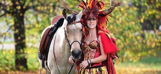 Vrouw in kostuum met paard in de vrije natuur 