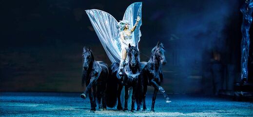 CAVALLUNA Legende der Wüste Amazone des Windes Giulia Giona als Amazone des Windes reitet stehend auf vier Friesen